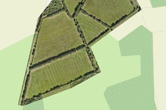 Orthorectified image showing agricultural fields, trees, and meadows, with a map background for soil analysis.